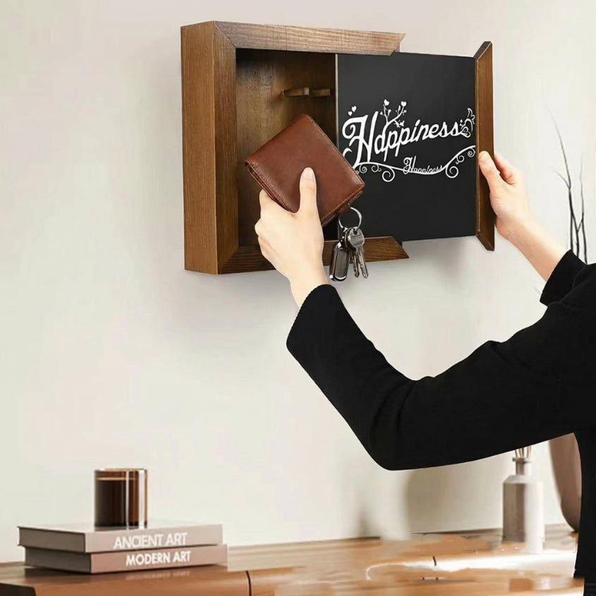 Wall-mounted box labeled 'Happiness' with a hand opening it to reveal a wallet and keys.